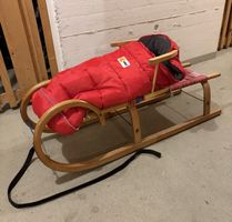 Holzschlitten KHW mit rotem Fusssack