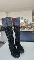 Bottes en daim ornées d'un cordon décoratif sur le devant.