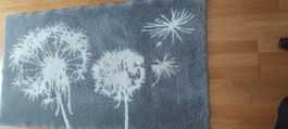 Badezimmerteppich L140 x B80 cm mit Pusteblumen Motiv grau.