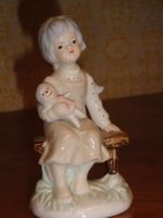 Porzellanfigur, sitzendes Kind mit Puppe
