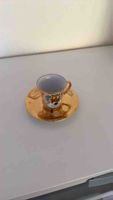 Kaffeetasse mit Untertasse goldfarben mit Wappen