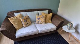 Sofa Rattangeflecht vintage mit 2 weissen Polstersitzkissen.
