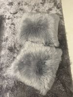 2 graue flauschige Kissen