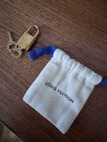 Cadenas Louis Vuitton doré avec 2 clés et pochette. Bon état
