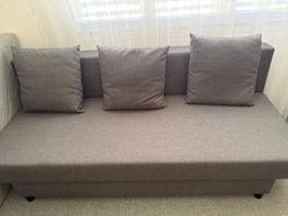 Schlafsofa grau mit Bettkasten und Kissen