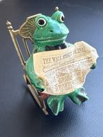 Frosch liest Wall Street Journal auf Schaukelstuhl