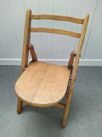 Chaise pliante vintage en bois clair pour enfant.