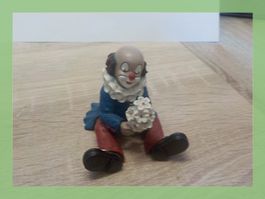 Niedlicher Gilde Clown Figur mit Blumenstrauß