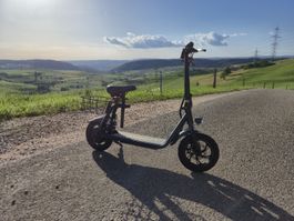 Neuwertiger Elektroroller U-Move mit Sattel und Korb