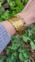 Bracciale rigido dorato effetto piuma regolabile