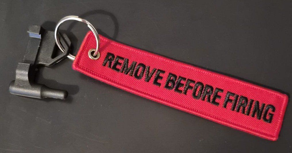 Portachiavi: 9mm chamber flag "remove before firing" – Nuovo (secondo la descrizione) da Genève venduto da CRDNX
