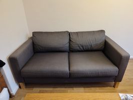 Graues 2er-Sofa mit Holzfüssen