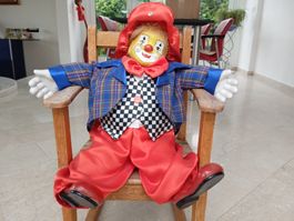 Clown-Figur auf einem antiken Kinderstuhl