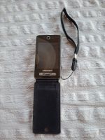 Samsung SGH-F480V Handy mit Zubehör und Taschen.