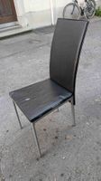 9 schwarze Stühle mit Gebrauchsspuren
