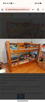 Etagenbett mit einem zusätzlichen Ausziehbett aus Holz .