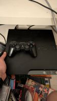 Console Sony PlayStation 3 noire avec une manette noire