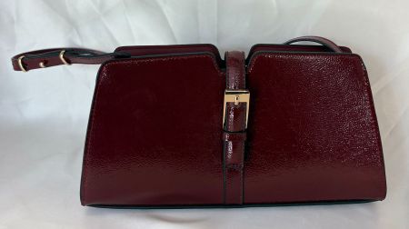 Handtasche in Rot mit goldenen Akzenten.