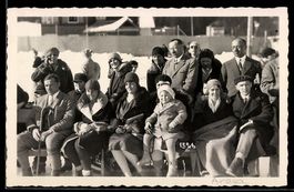 Foto-AK Arosa, Gruppenbild sitzender Personen in Winterkleid