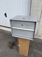 Grauer Briefkasten mit Schlüssel