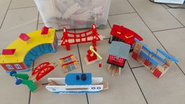 Eine Kiste Holzbahnen mit Bahnhöfe, Brücke, Schiff, ....