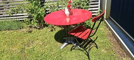 Rotes Gartentisch ohne Stühlen für Sommerabende!