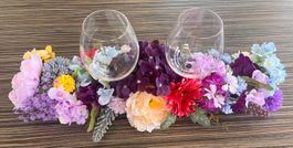 Deko-Arrangement mit Kunstblumen und 2 Weingläsern