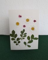 Grusskarte mit echten Blüten und Blättern