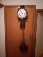 antike Wanduhr mit Pendel zum aufziehen mit Gewichten.