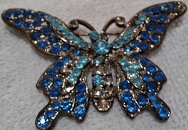 Broche papillon métal avec strass bleus 