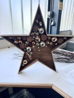 Holzstern weihnachtlich dekoriert mit Beleuchtung