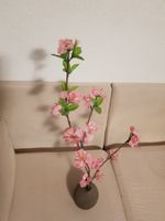 Vase in Form einer Kokosnuss mit Kunstblumen