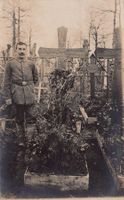 WK I: Friedhof, Soldat posiert neben Grab eines Kameraden