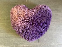 Lilafarbenes, flauschiges Kissen in Herzform