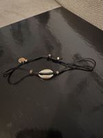 Braccialetto con conchiglia e cordino nero regolabile