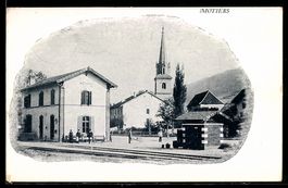 AK Motiers, Bahnhofsgebäude mit Bahnsteig und Kirche