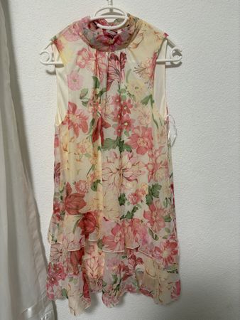 Sleeveless floral blouse with ruffles and neck tie