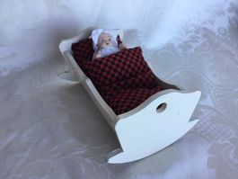 Älteres Porzellanbaby mit Wiege