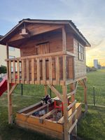 Cabane en bois avec toboggan et bac à sable