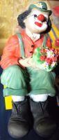 clown sitzend mit blumenstrauss