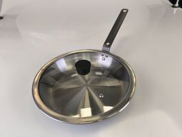 Gebrauchte Bratpfanne aus Edelstahl mit Deckel.