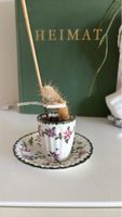 Kleine Pflanze im Espresso Tässchen mit Unterteller