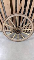 Grande roue ancienne de charrette en bois cerclée de fer