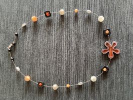 Modeschmuck-Kette mit Blume und Perlen in Herbstfarben.