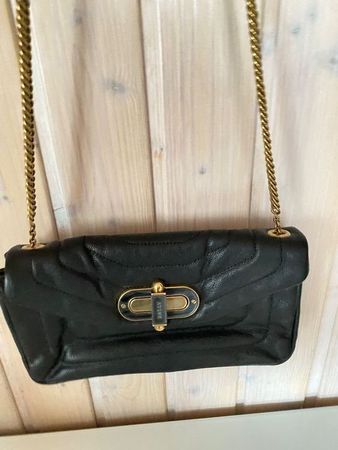 Schicke schwarze Ledertasche mit goldener Kette