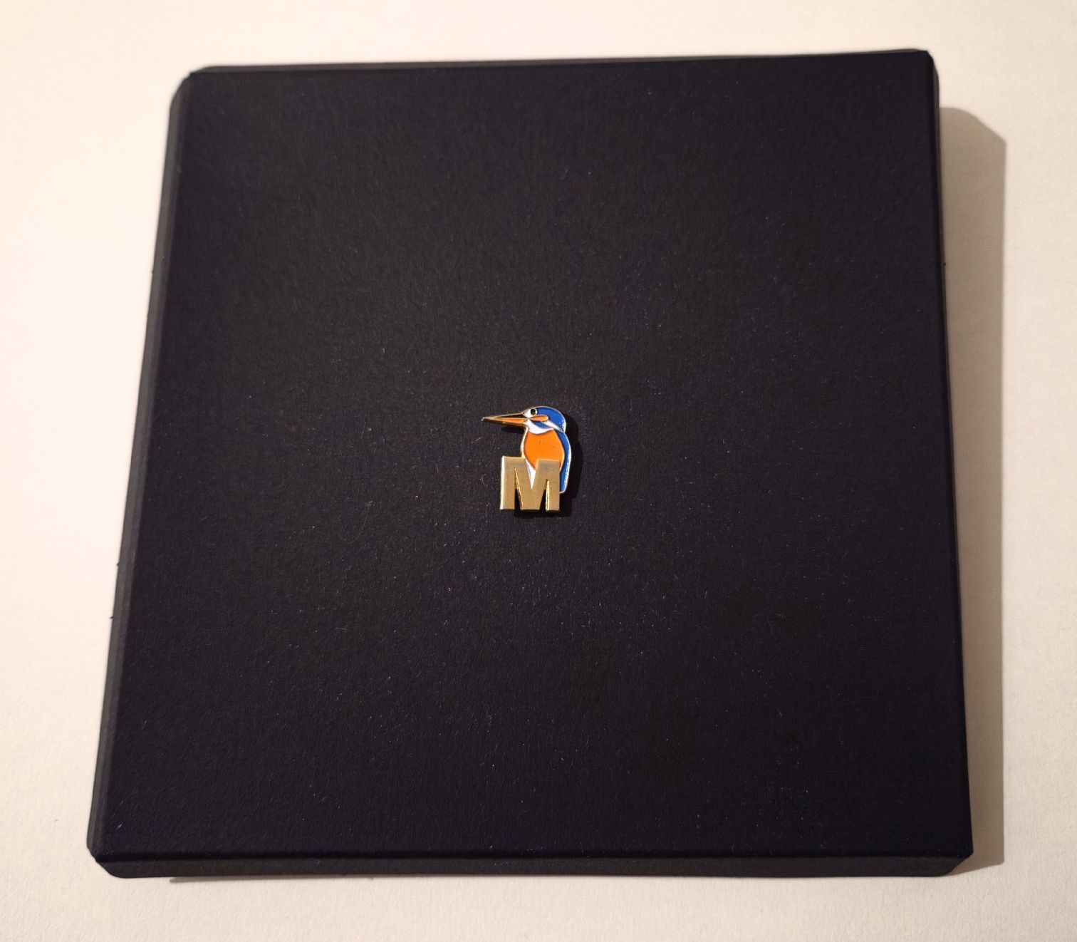 Placchette & Badge: Ansteckpin Eisvogel mit M (Migros) – Nuovo e nell'imballaggio originale da Schaffhausen venduto da Alforall