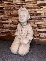 Sitzende Jungen-Figur, Stein