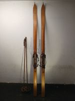 Alte Holzski mit Skistöcken und Bindung