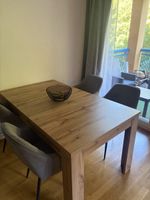 Tavolo da pranzo in legno con quattro sedie grigie