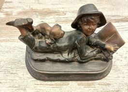Boy reading with his dog in bronze.
